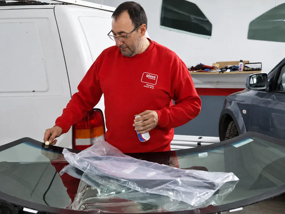 Empleado de A Mariña Glass trabajando sobre un parabrisas en el taller