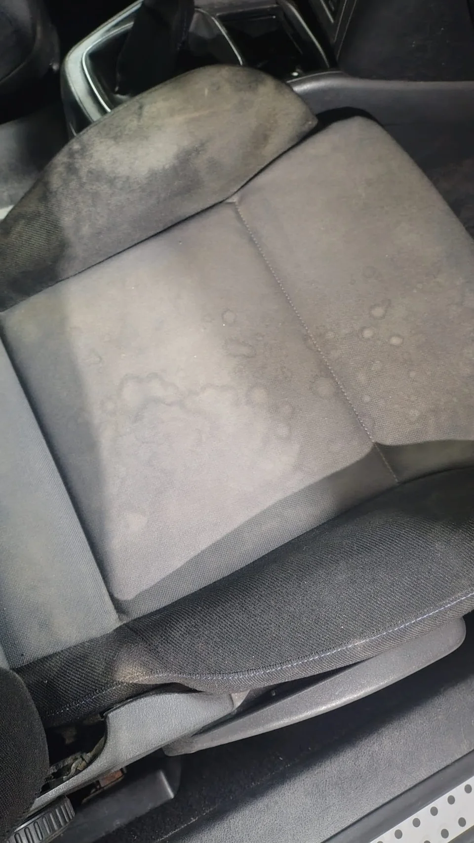 Asiento delantero antes de la limpieza, con manchas visibles